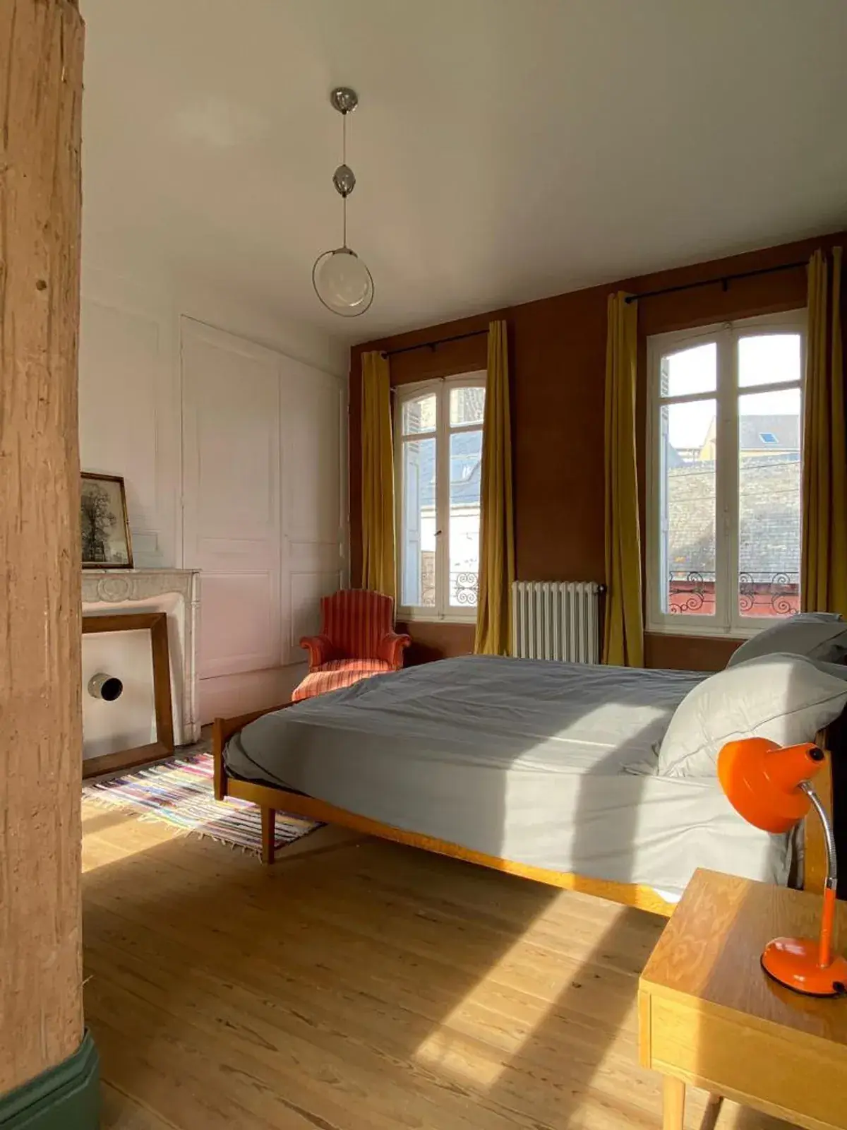 Chambre aux murs ocre avec cheminée en marbre et lit en chêne