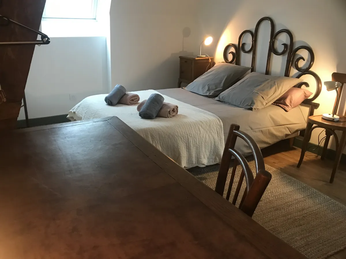 Chambre mansardée avec lit double et tête de lit en osier