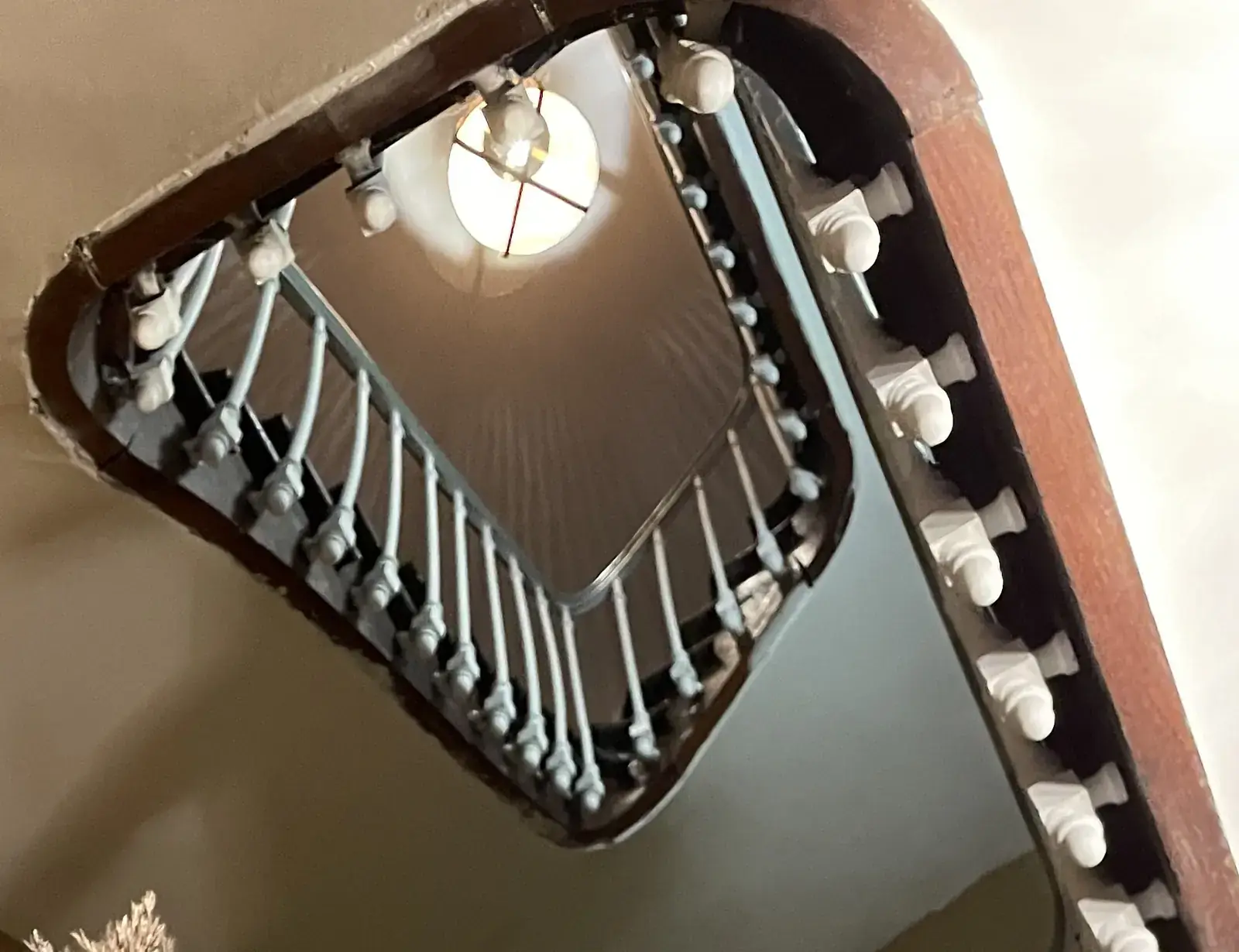 La cage d'escalier de la Villa Marguerite et sa rampe d'origine, vue dans le miroir de l'entrée
