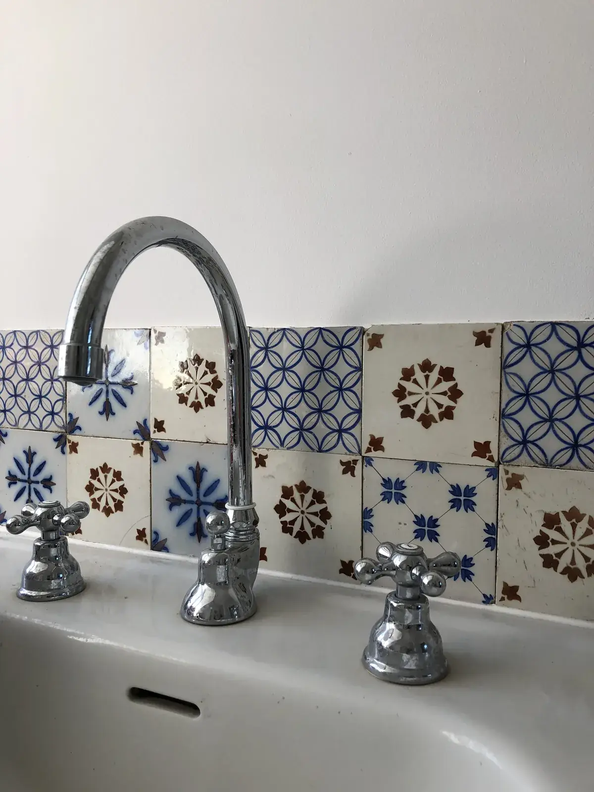 Lavabo rétro et robinetterie ancienne sur carreaux bleus
