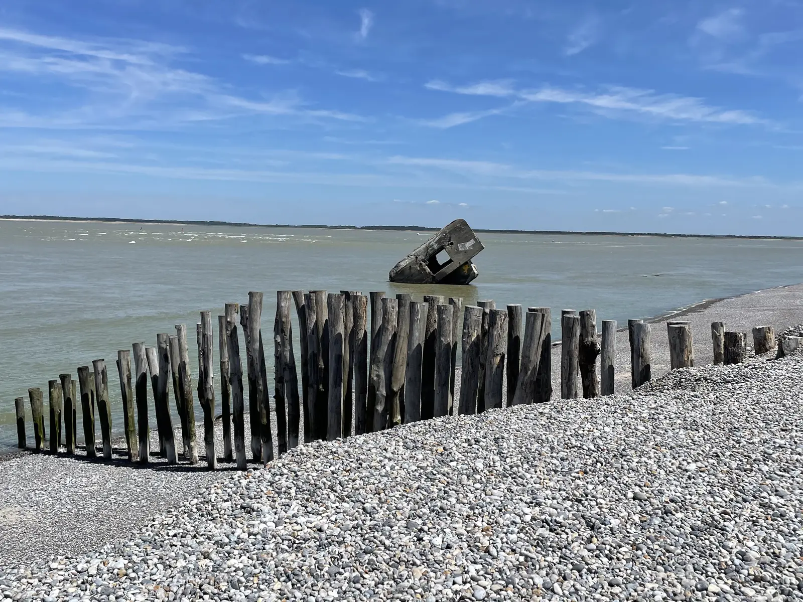 Épis de bois et ancien blockhaus sur la plage de galets, vers la Pointe du Hourdel