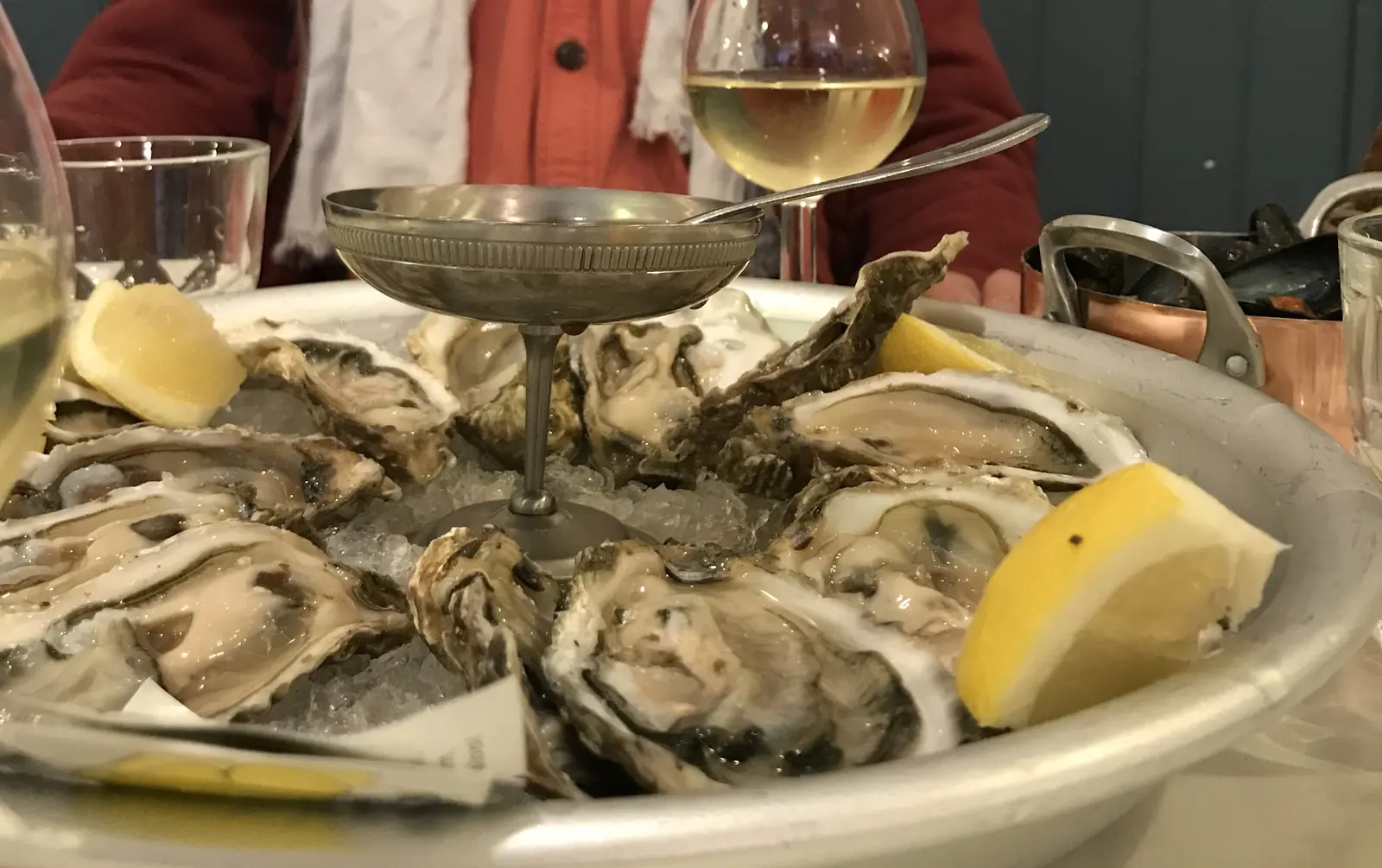 Un plateau d'huîtres et un verre de vin blanc sur la table de la maison