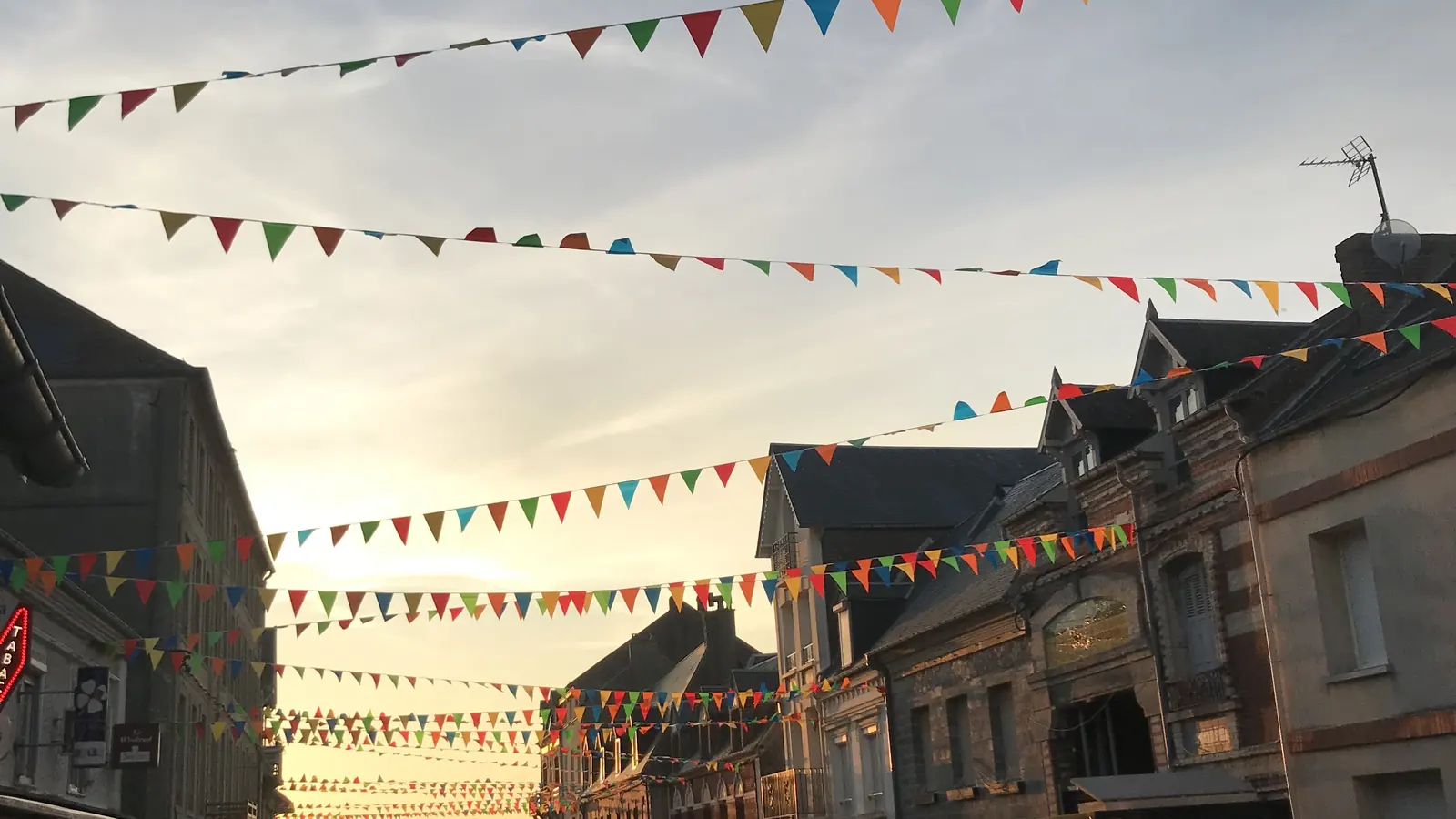La rue commerçante d'Ault pavoisée de fanions, un soir d'été